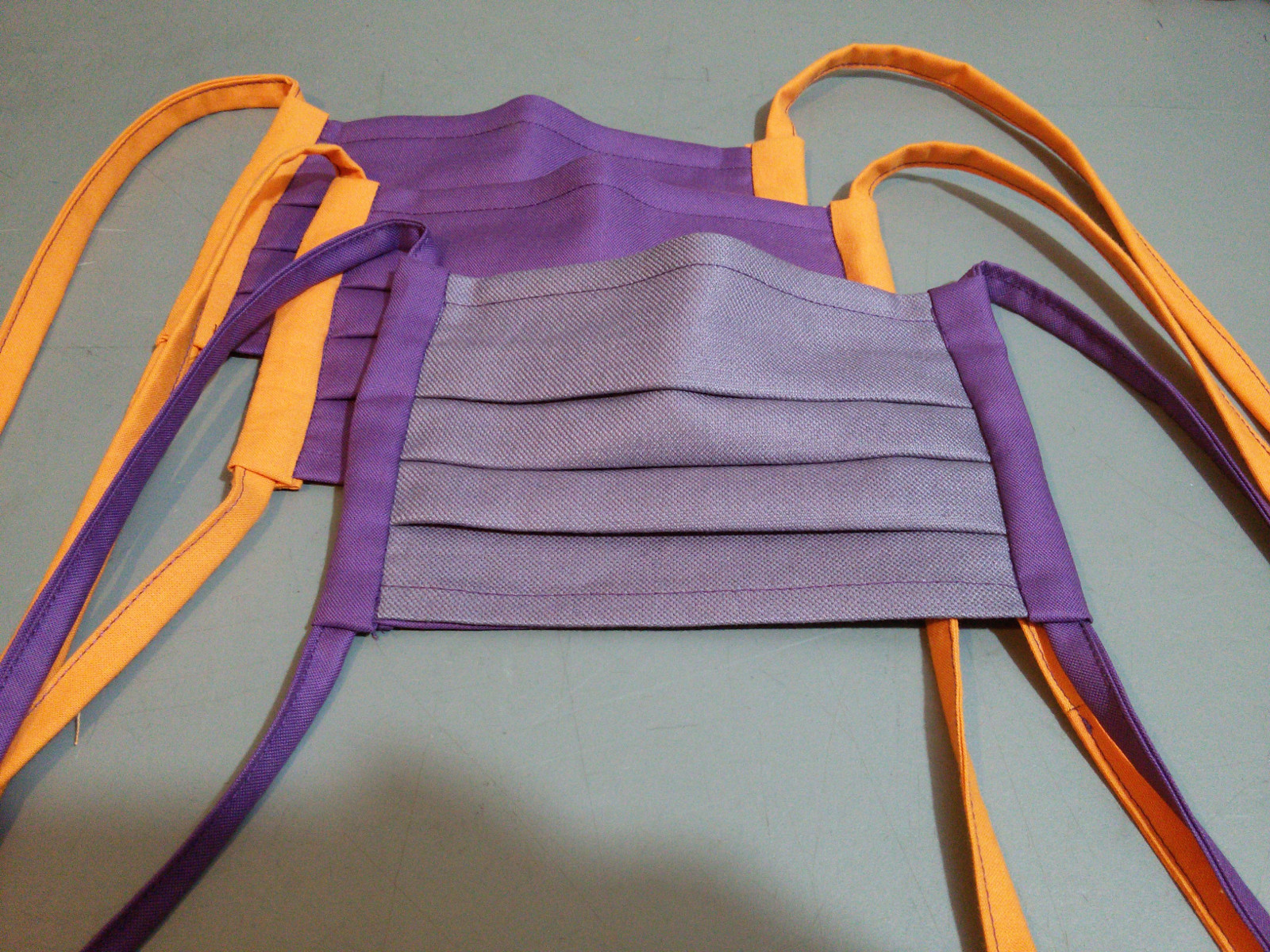 Bild: Stoffmasken in orange und violett.