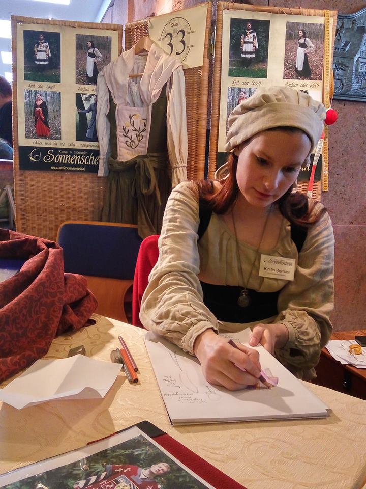 Foto von mir an meinem Stand auf der LwC 2016, wie ich eine Gewandung skizziere.